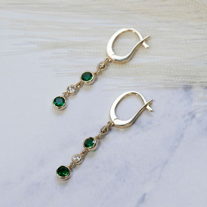 Yellow gold dangling earring with 2 green and white zircons