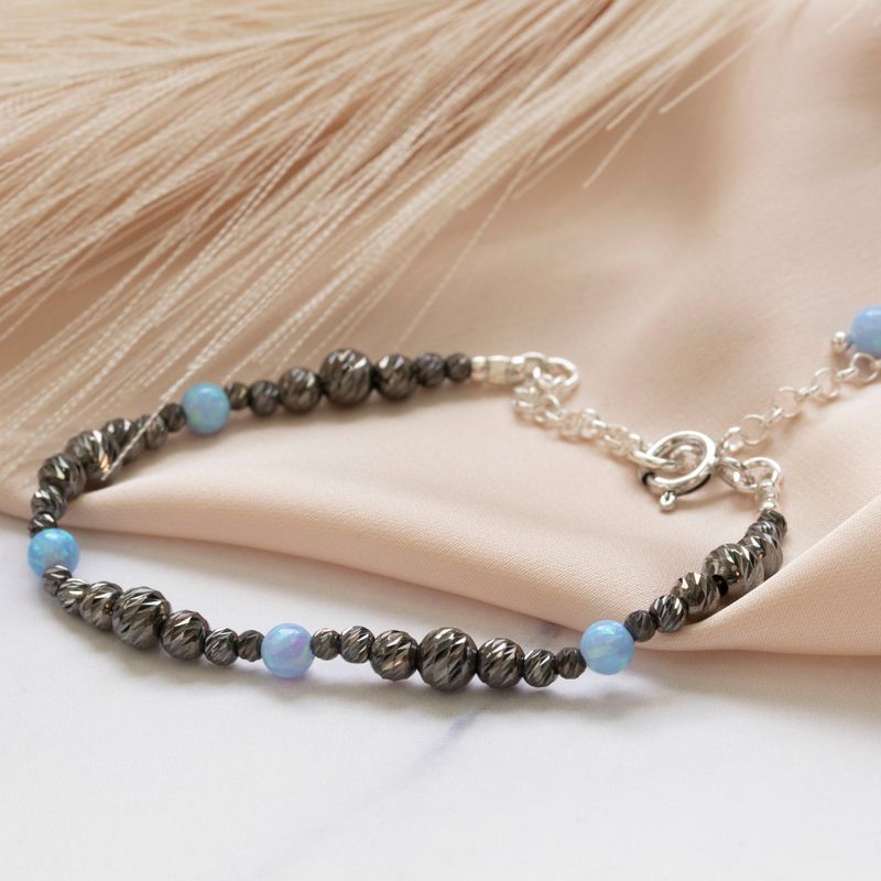 Silver bracelet with rough black beads with blue opal beads and clasp