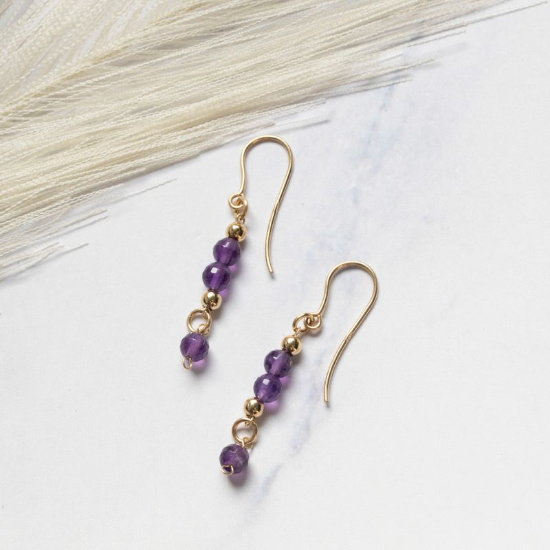 Yellow gold dangling earrings with gold and amethyst beads