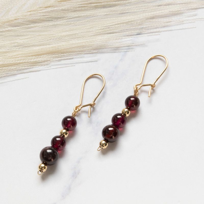 Yellow gold dangling earrings with gold and garnet beads