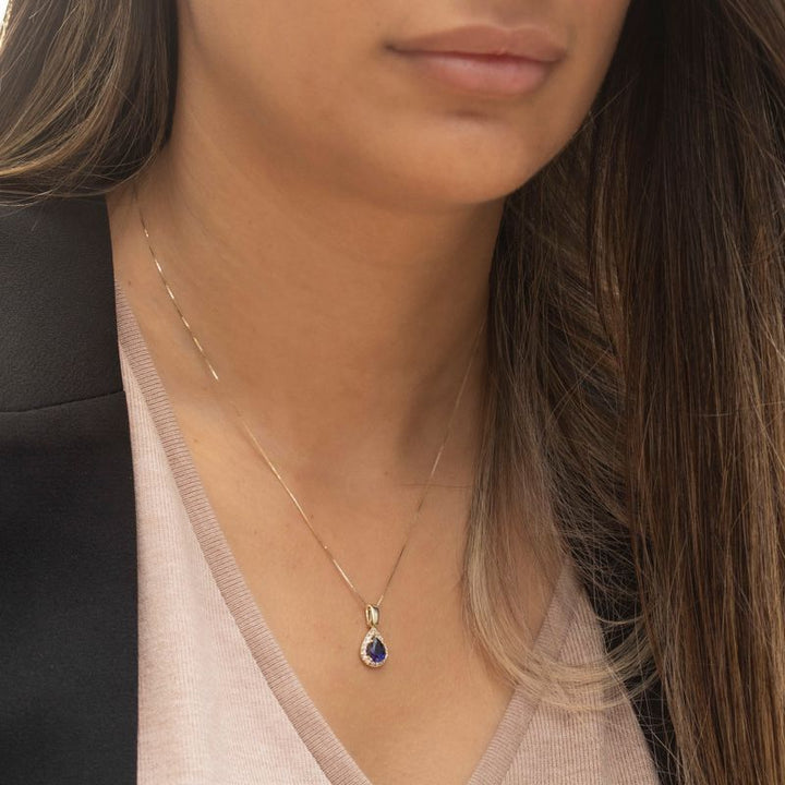 Yellow gold drop necklace with white zircons and a blue zircon in the center