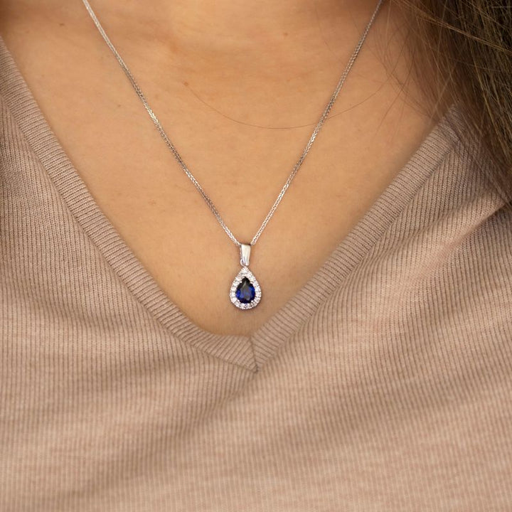 White gold drop necklace with white zircons and a blue zircon in the center