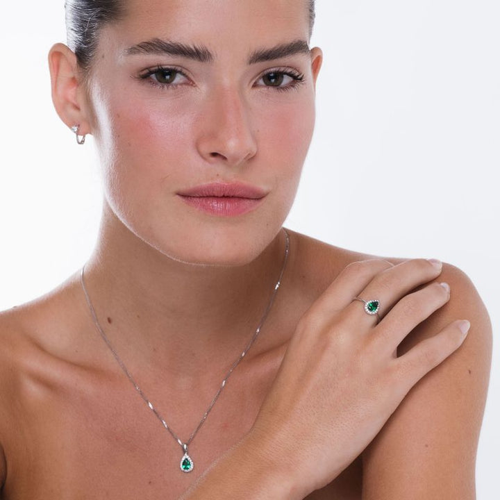 White gold drop necklace with white zircons and a green zircon in the center