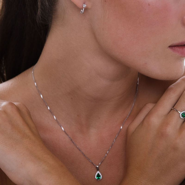 White gold drop necklace with white zircons and a green zircon in the center