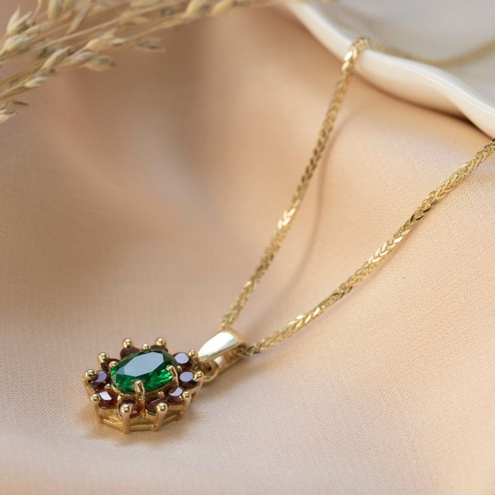 Lucia pendant yellow gold with garnet stones and green zircon in the middle