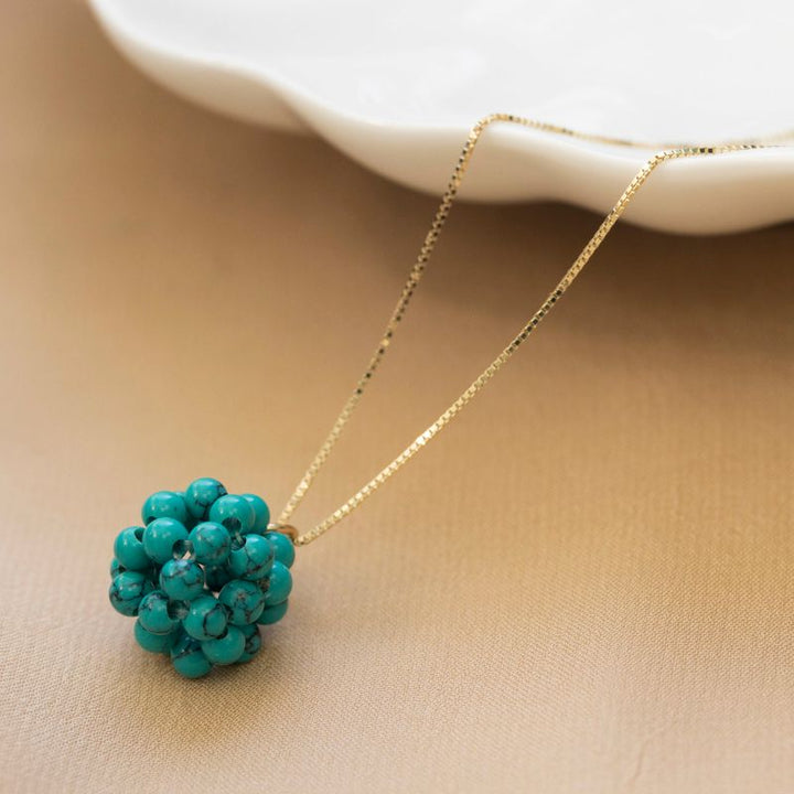 Ball-shaped turquoise bead pendant with gold hanger