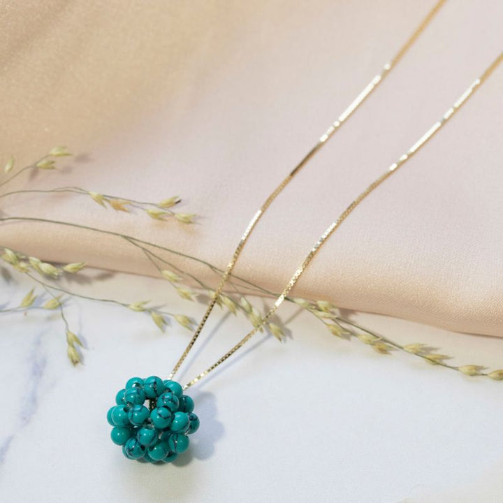 Ball-shaped turquoise bead pendant with gold hanger