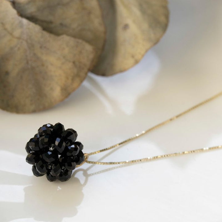 Ball-shaped black bead pendant with gold hanger