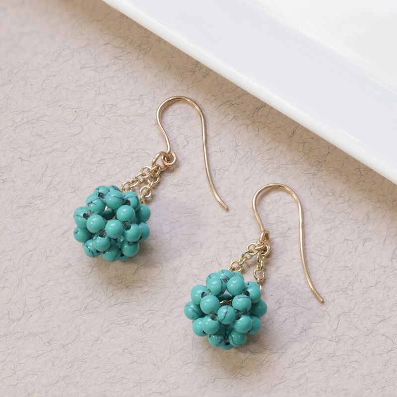 Yellow gold earrings with turquoise beads in a ball